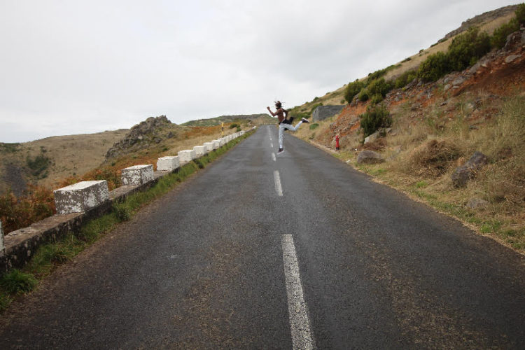 A person standing on the side of a road.