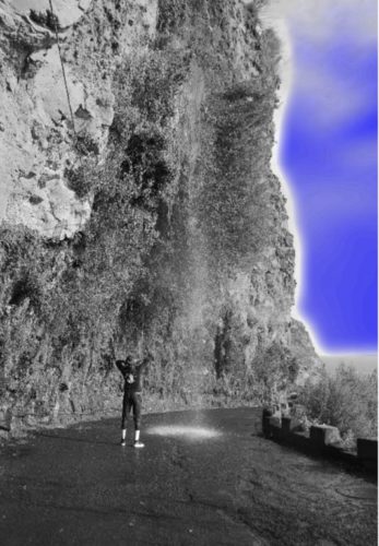 A person standing in front of a waterfall.