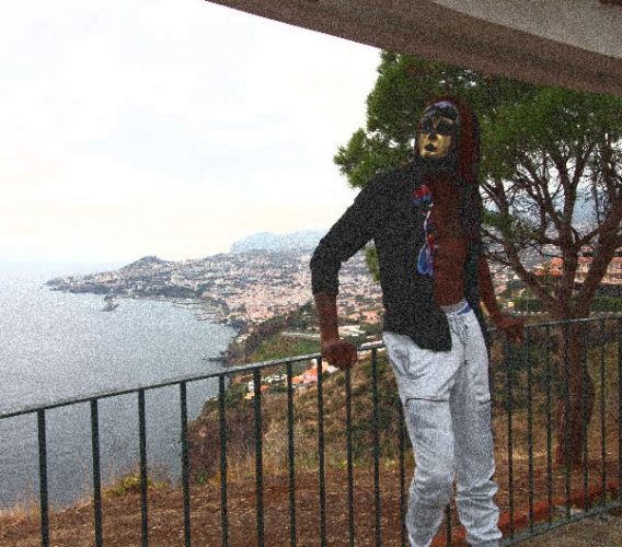 A man standing on top of a balcony near the ocean.