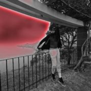 A person standing on top of a fence.