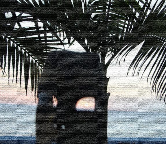 A statue of a person sitting under a palm tree.