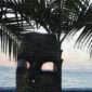 A statue of a person sitting under a palm tree.
