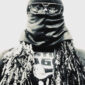 A man with long dreadlocks wearing sunglasses and a leather jacket.