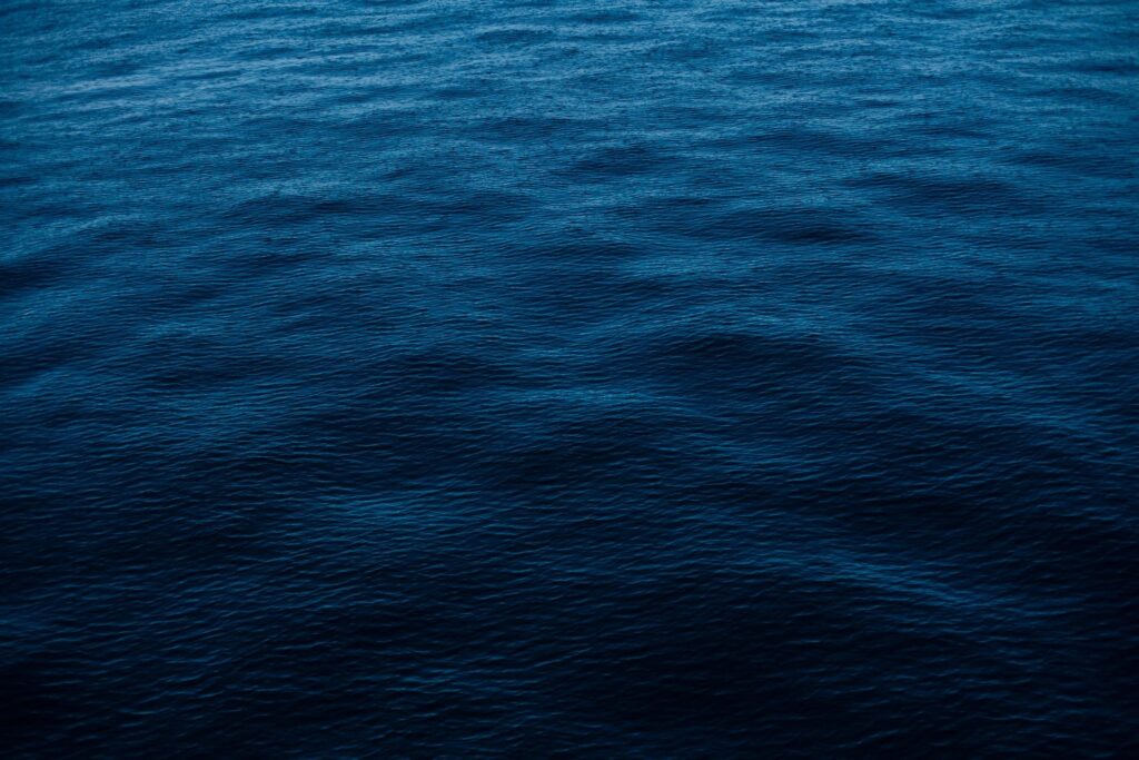 A dark blue sea with waves in the water.